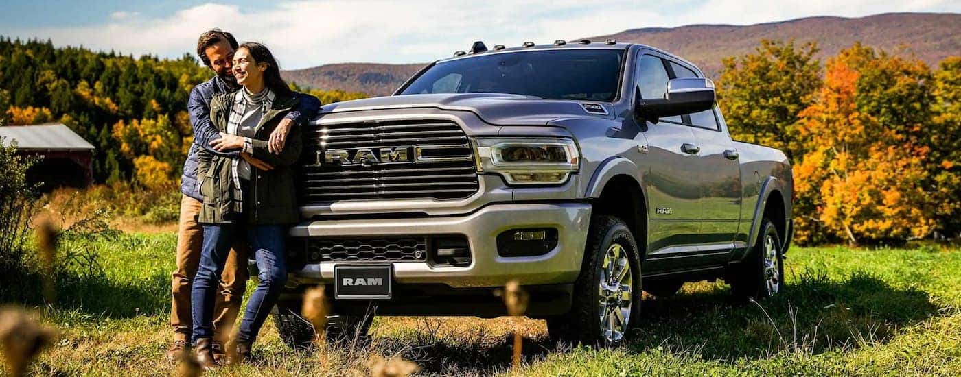 A couple is standing in front of a grey 2022 Ram 2500.