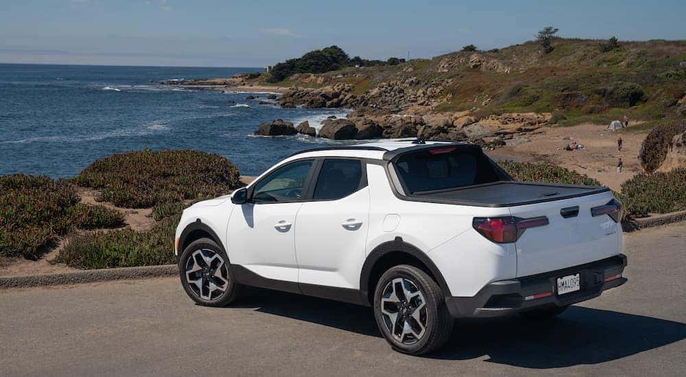 White 2023 Hyundai Santa Cruz parked near a coastline.