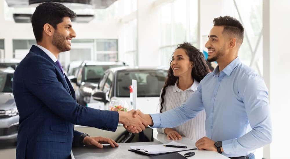 Customers are shown shaking hands with an employee after deciding to "sell my car".