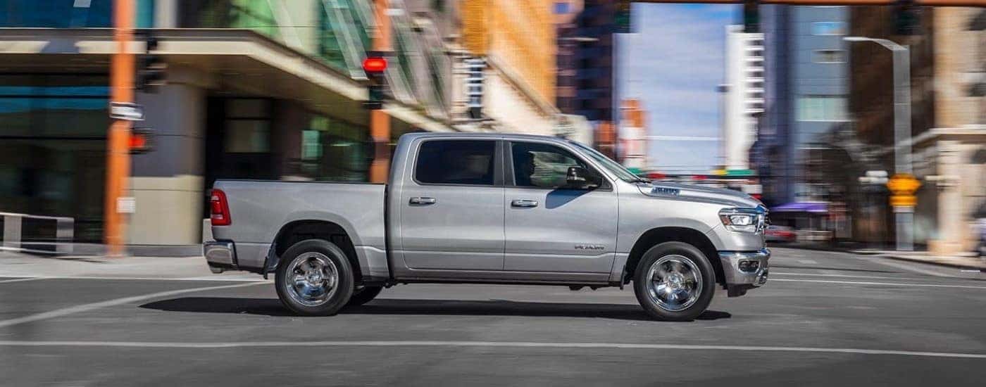 A silver 2019 Ram 1500 is shown driving to visit a used car dealer near Amsterdam.