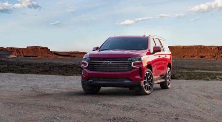 A red 2021 Chevy Tahoe is shown parked off-road.