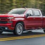 A red 2021 Chevy Silverado 1500 Z71 is shown driving to a used car dealer near Amsterdam.