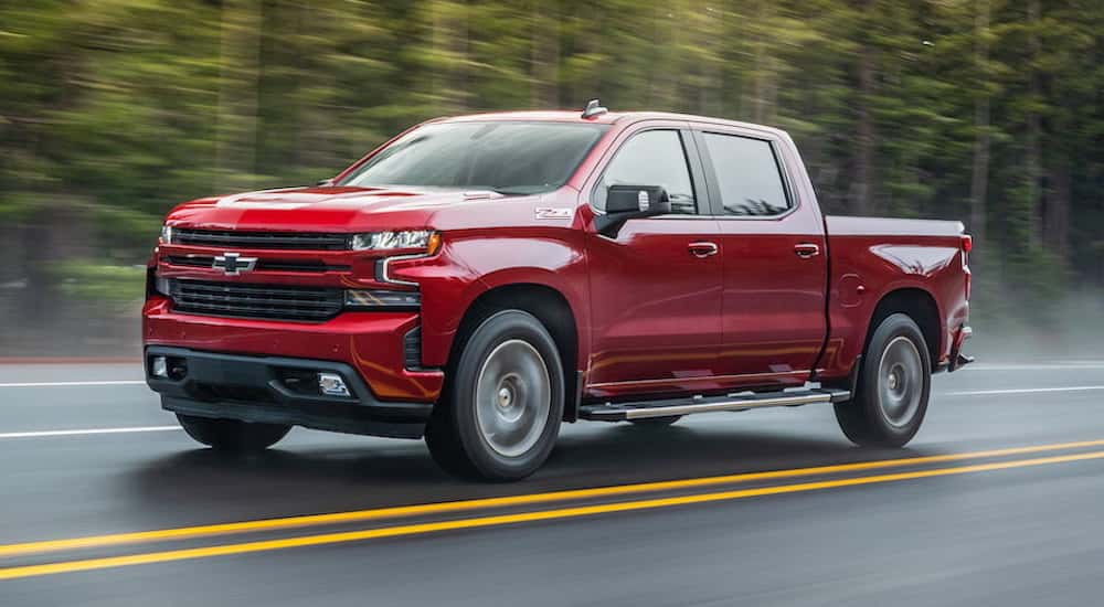 Red 2021 Chevy Silverado 1500 Z71 driving to a used car dealer near Amsterdam.