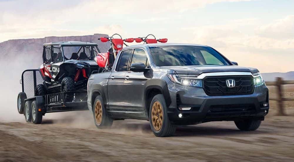 Grey 2022 Honda Ridgeline HPD towing an ATV.