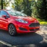 An orange 2015 Ford Fiesta is shown from the front at an angle.