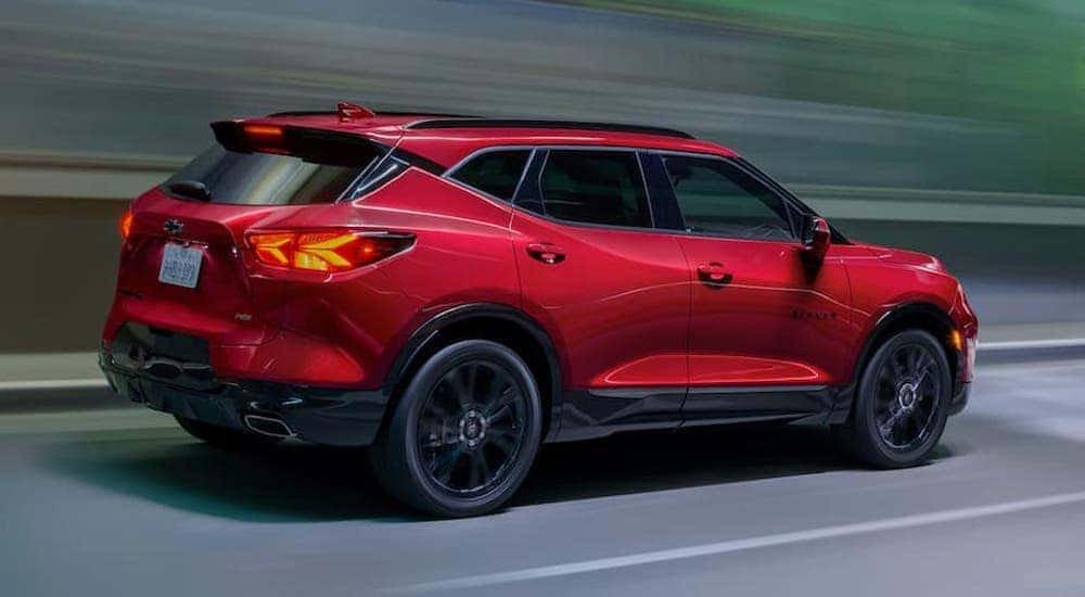 A red 2021 Chevy Blazer RS driving to view a used Chevy for sale.