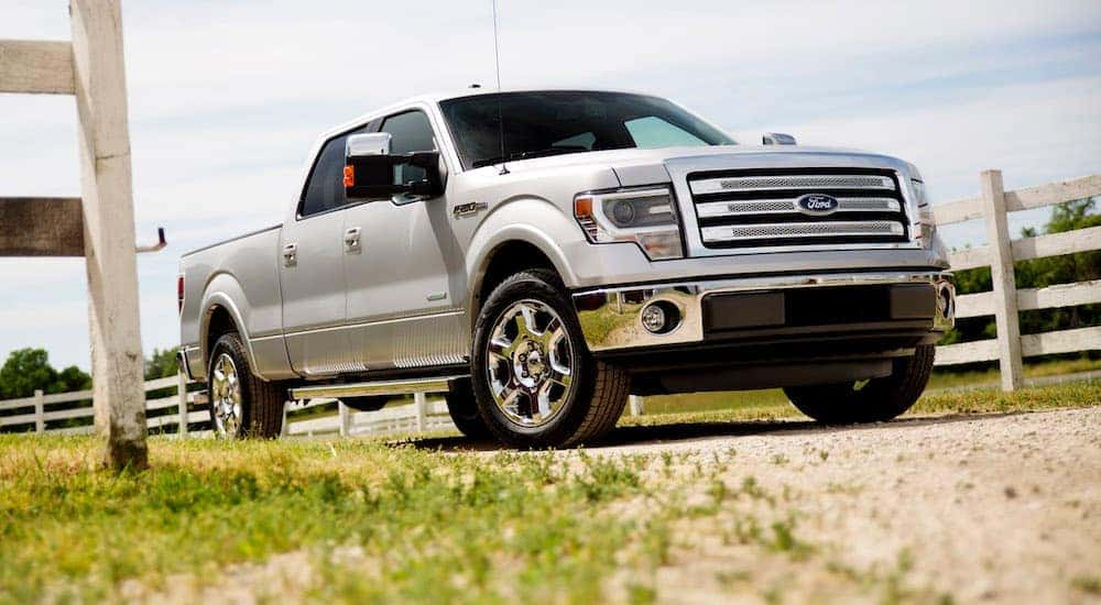Silver used 2014 Ford F-150 for sale near Schenectady parked by fence. 