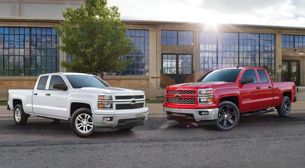 Two 2015 Chevy Silverado 1500 for sale near Schenectady parked outside of a dealership