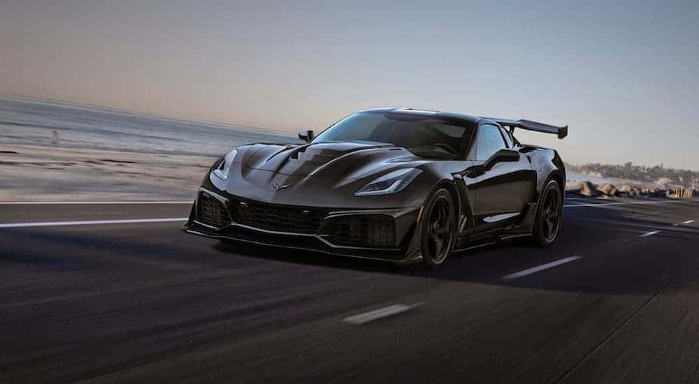 A black 2019 Chevy Corvette ZR1 driving to view a used Chevy for sale near Schenectady.