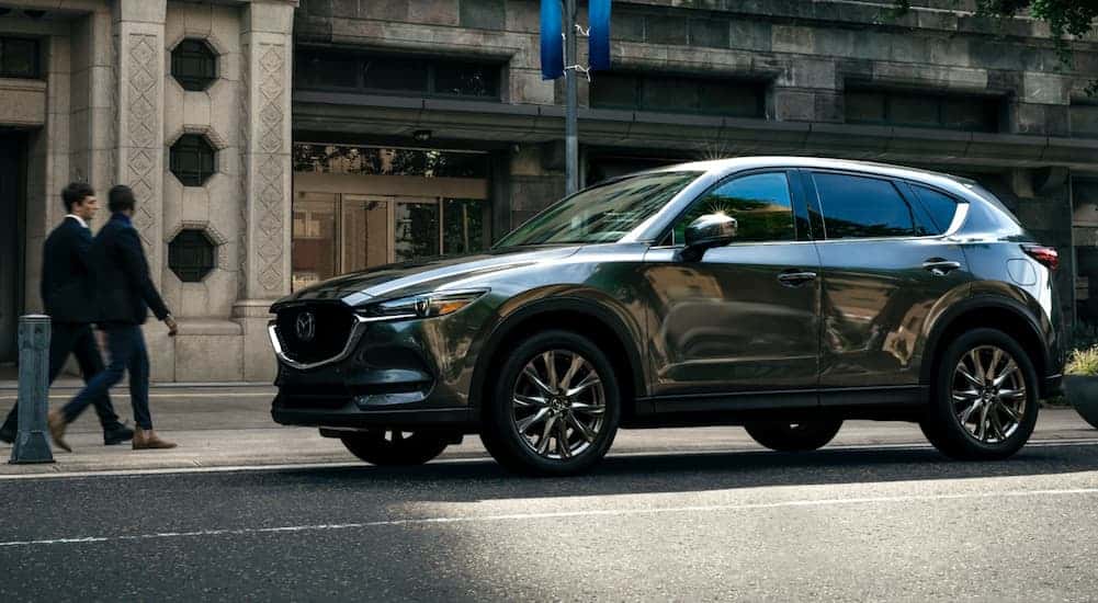 Black 2021 Mazda CX-5 driving through a city