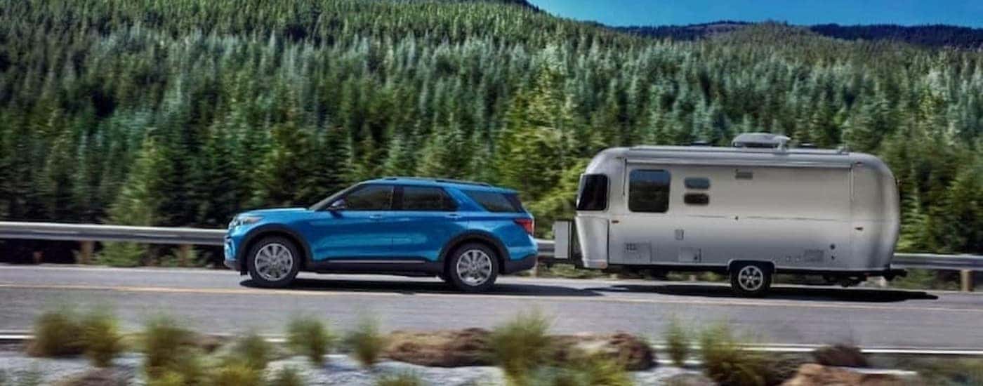 A blue 2023 Ford Explorer towing a trailer/