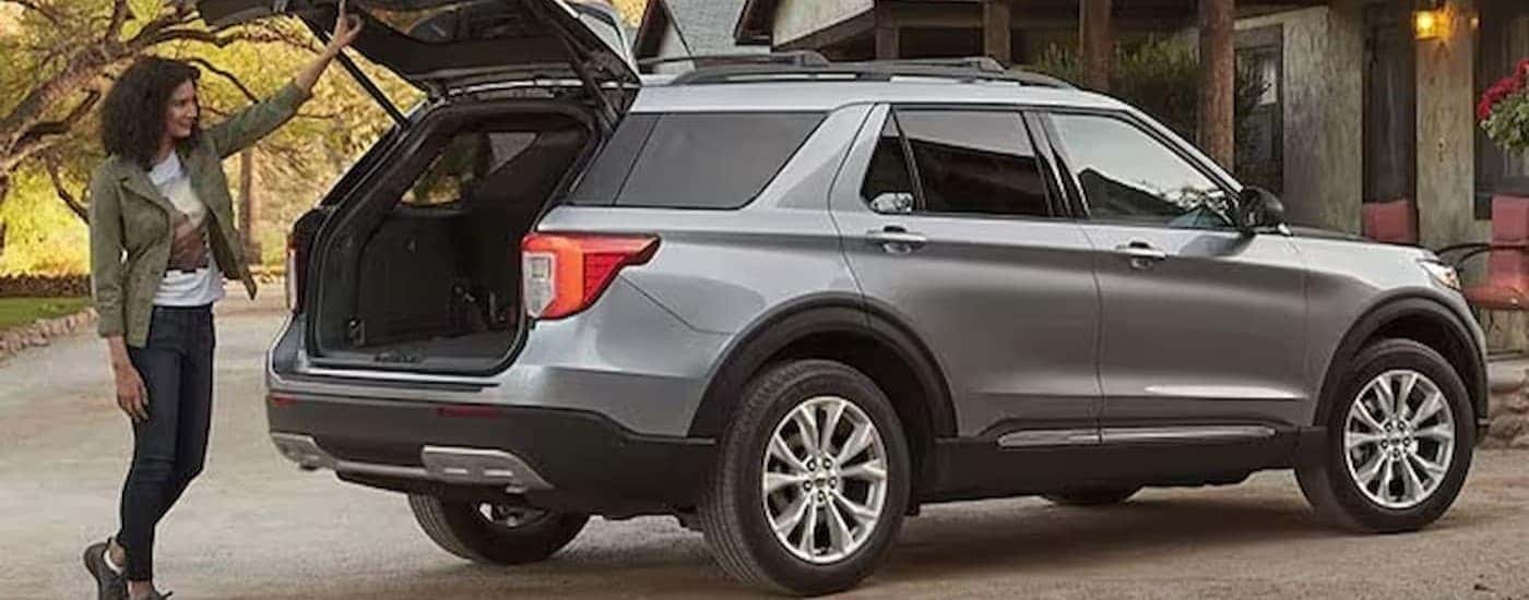 A person standing near an open hatch on a silver 2024 Ford Explorer.