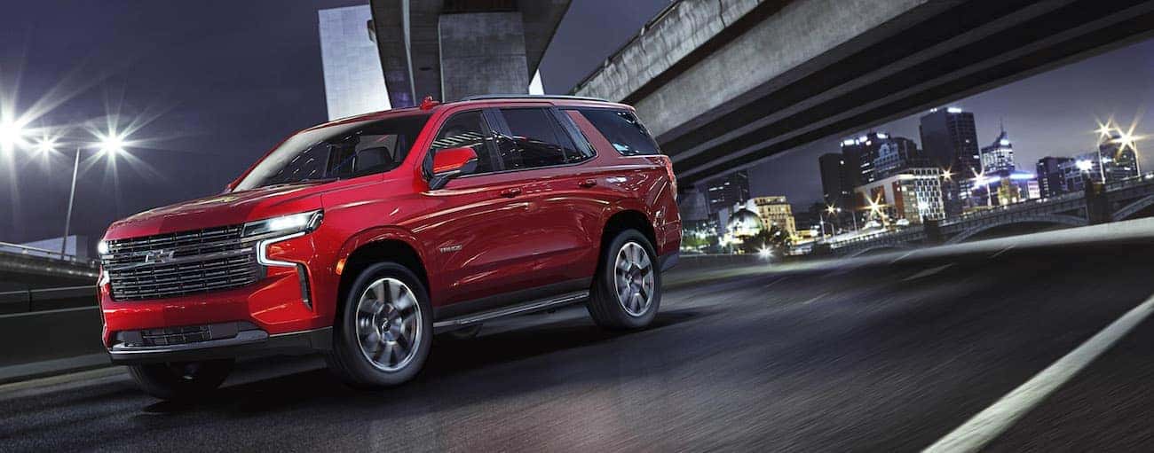 Red 2021 Chevy Tahoe driving in a city.
