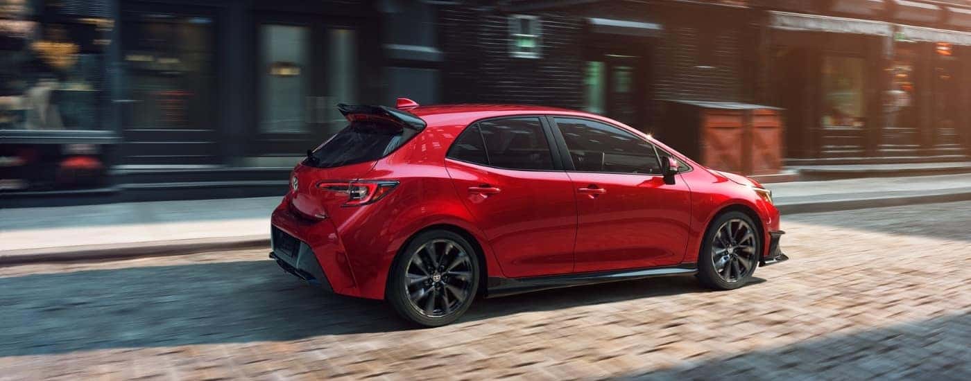 A red 2021 Toyota Corolla is shown parked near a curb.