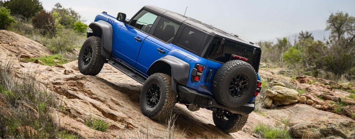Blue 2024 Ford Bronco Raptor parked off-road on an incline
