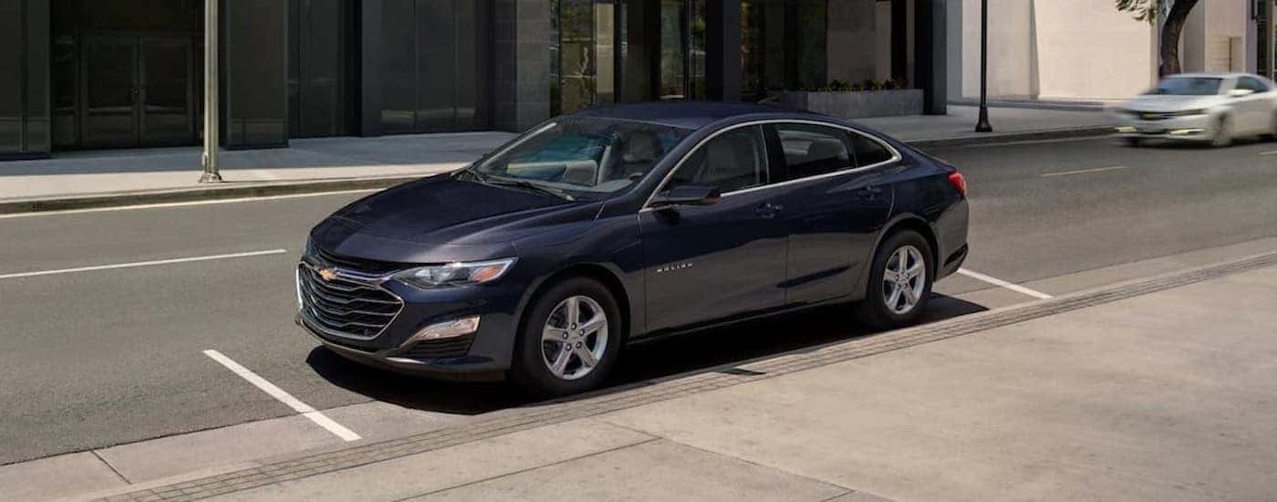 A blue 2023 Chevy Malibu is shown parked after viewing used cars for sale near Rensselaer.