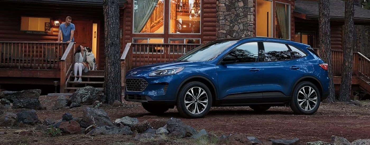 Blue 2022 Ford Escape parked in front of a log cabin