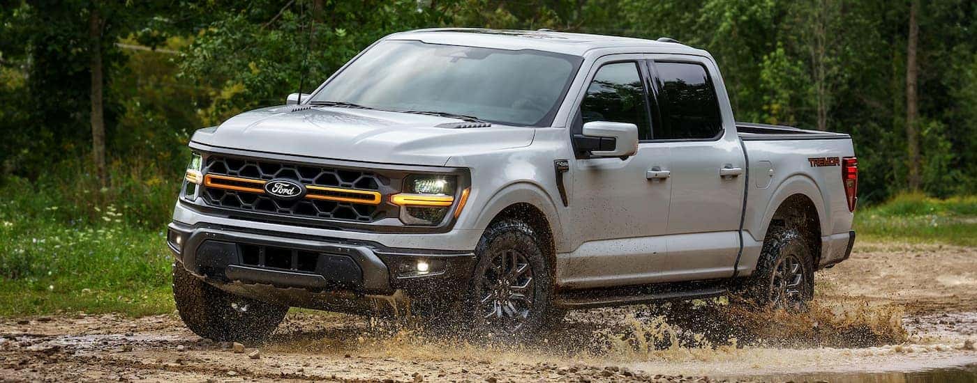 Grey 2025 Ford F-150 off-roading on a muddy trail