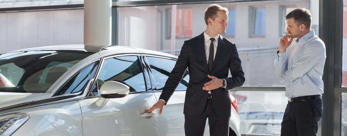 A salesperson opening the door for a prospective customer