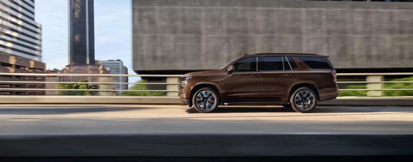 A brown 2022 Chevy Tahoe side-view driving.