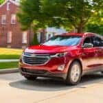 Red 2018 Chevy Equinox driving down a road.
