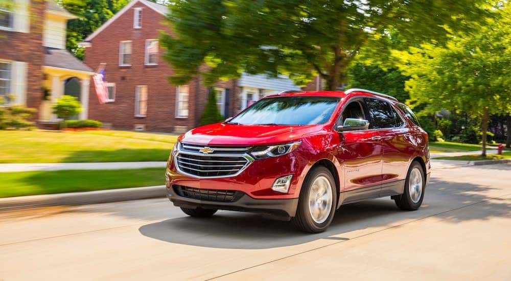 Red 2018 Chevy Equinox driving down a road.