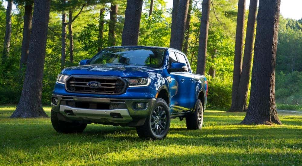 Blue 2020 Ford Ranger truck parked on grass next to tall trees
