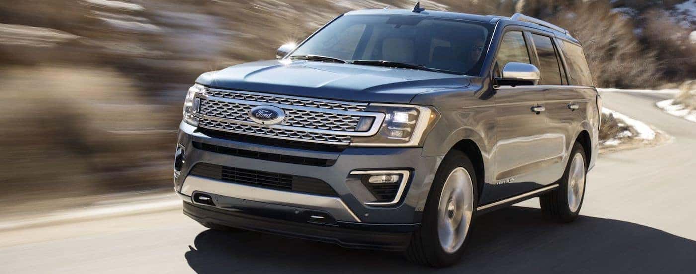 A blue 2018 Ford Expedition is driving on a winding road near Albany, NY.