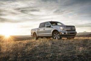 Gray 2018 Ford F-150 pick-up truck with cab in field with sunrise