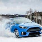 2018 Ford Focus RS driving in the snow on a hilltop during winter
