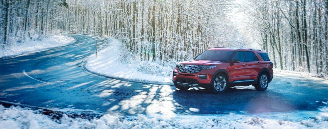 A red 2020 Ford Explorer is driving on a snowy road near Albany, NY.