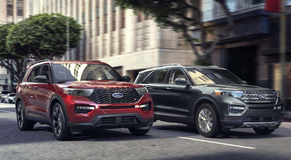Red and grey 2020 Ford Explorer's are stopped at a red light in a city near Albany, NY.