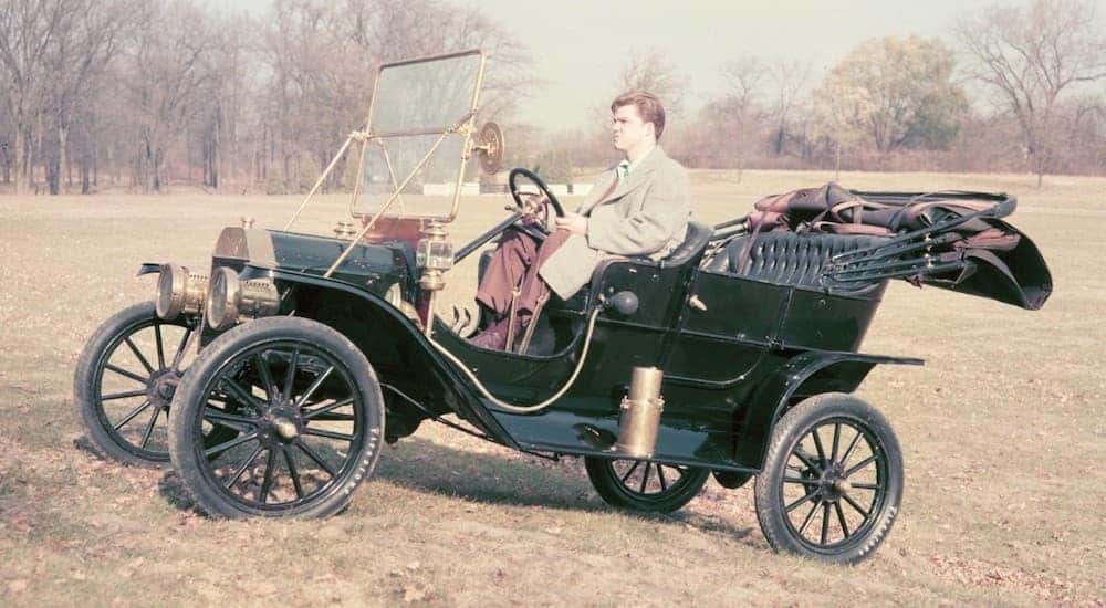 A man is driving a 1908 Ford Model T in a field near Albany, NY.