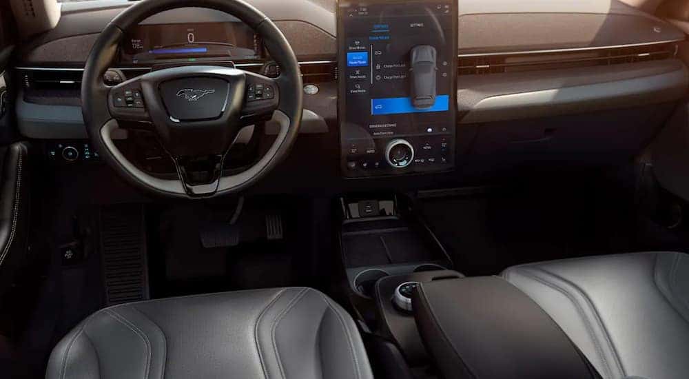 The front black leather interior of a 2021 Mach-E is shown. 