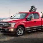 A red 2018 Ford F-150, which is a popular option among used Ford trucks, is parked in front of a lake near Albany, NY.