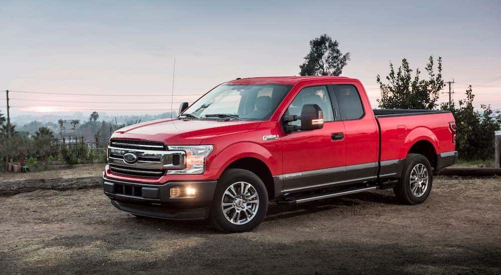 A red 2018 Ford F-150, which is a popular option among used Ford trucks, is parked in a parking lot near Albany, NY.