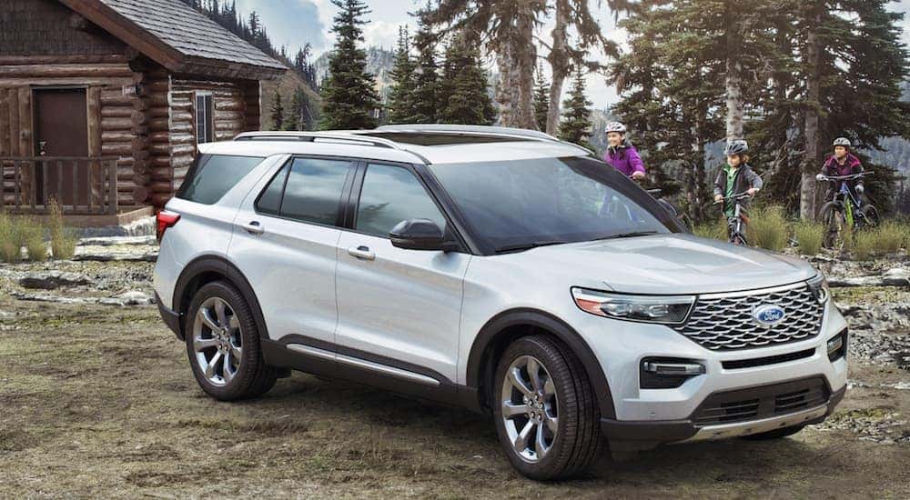 A white 2020 Ford Explorer is parked next to a remote cabin in the Albany, NY, woods.