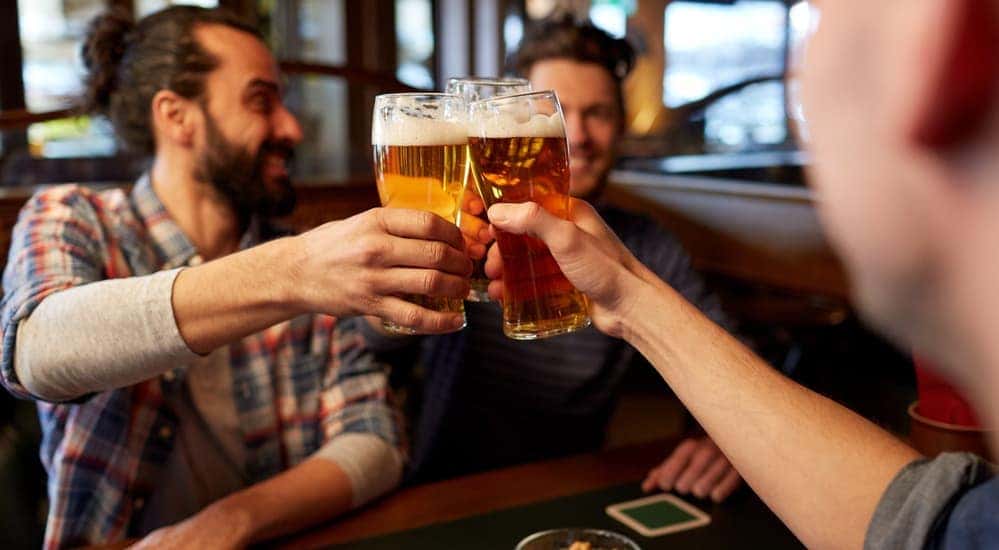 Smiling friends are drinking beer near Hyde Park, NY.