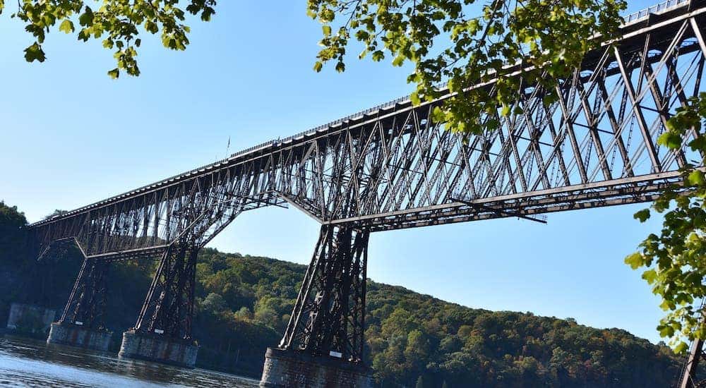 A lower shot of the Poughkeepsie, NY Walkway bridge is against a blue sky.