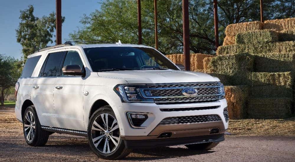 White 2020 Ford Expedition SUV parked next to brown poles and a stack of hay
