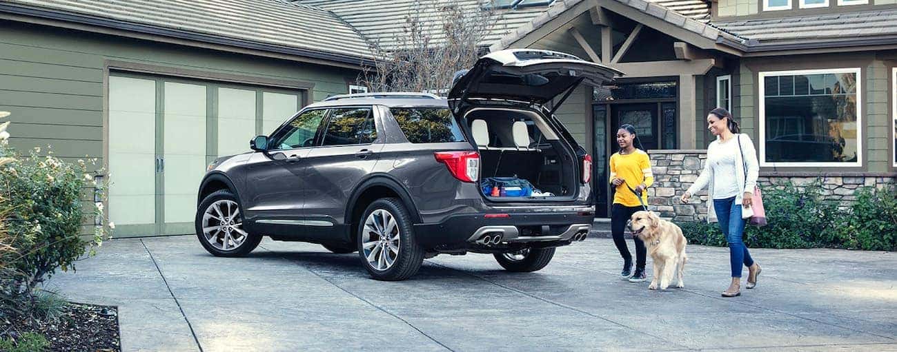 A grey 2021 Ford Explorer with the hatch open is parked at a green house.