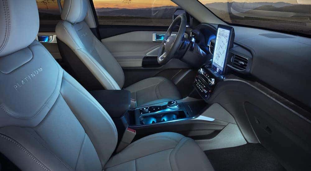 The white interior is shown from the side at dusk with a glow from the screen.