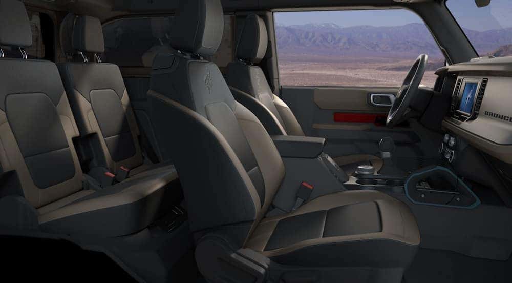 The interior of a 2021 Ford Bronco Wildtrack is shown from the side at dusk.