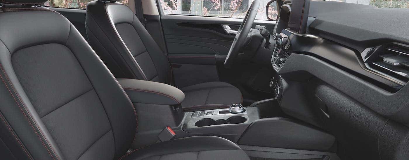 The black front seats with red accent stitching is shown from the passenger seat in a 2021 Ford Escape.