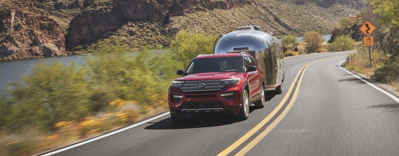 A red 2021 Ford Explorer is shown from the front towing an Airstream camper.