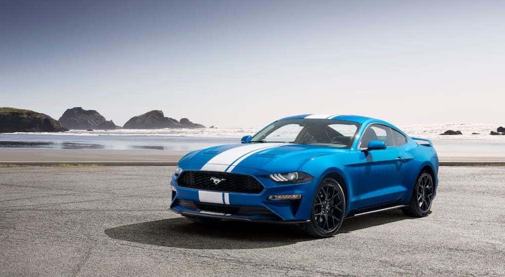 A blue 2020 Ford Mustang is parked on a beach.
