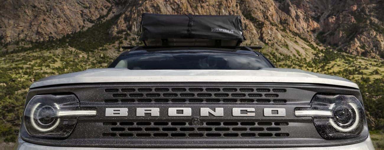 The front grille of a white 2021 Ford Bronco Sport is shown from a low angle.