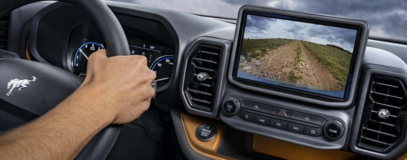 The interior of a 2021 Ford Bronco Sport shows the steering wheel and infotainment screen.