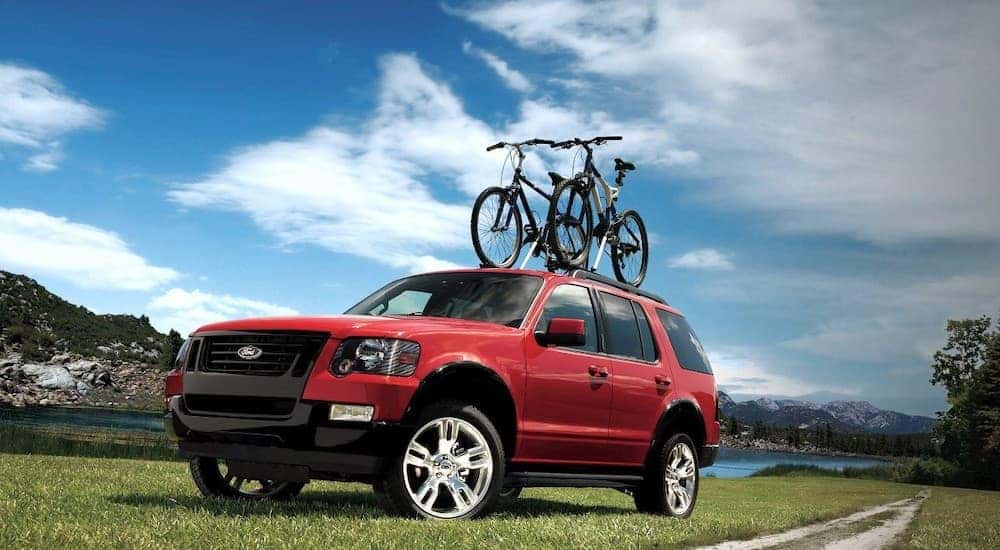 A red 2021 Ford Explorer is shown with bikes on the roof.