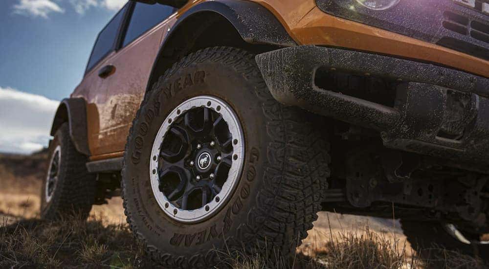 A close up shows the front left tire of a yellow 2021 Ford Bronco after leaving a NY Ford Bronco dealership.